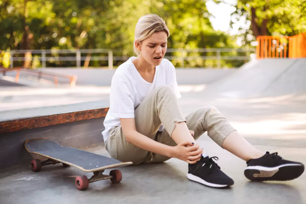 Girl Holding Her Painful Leg With Skateboard